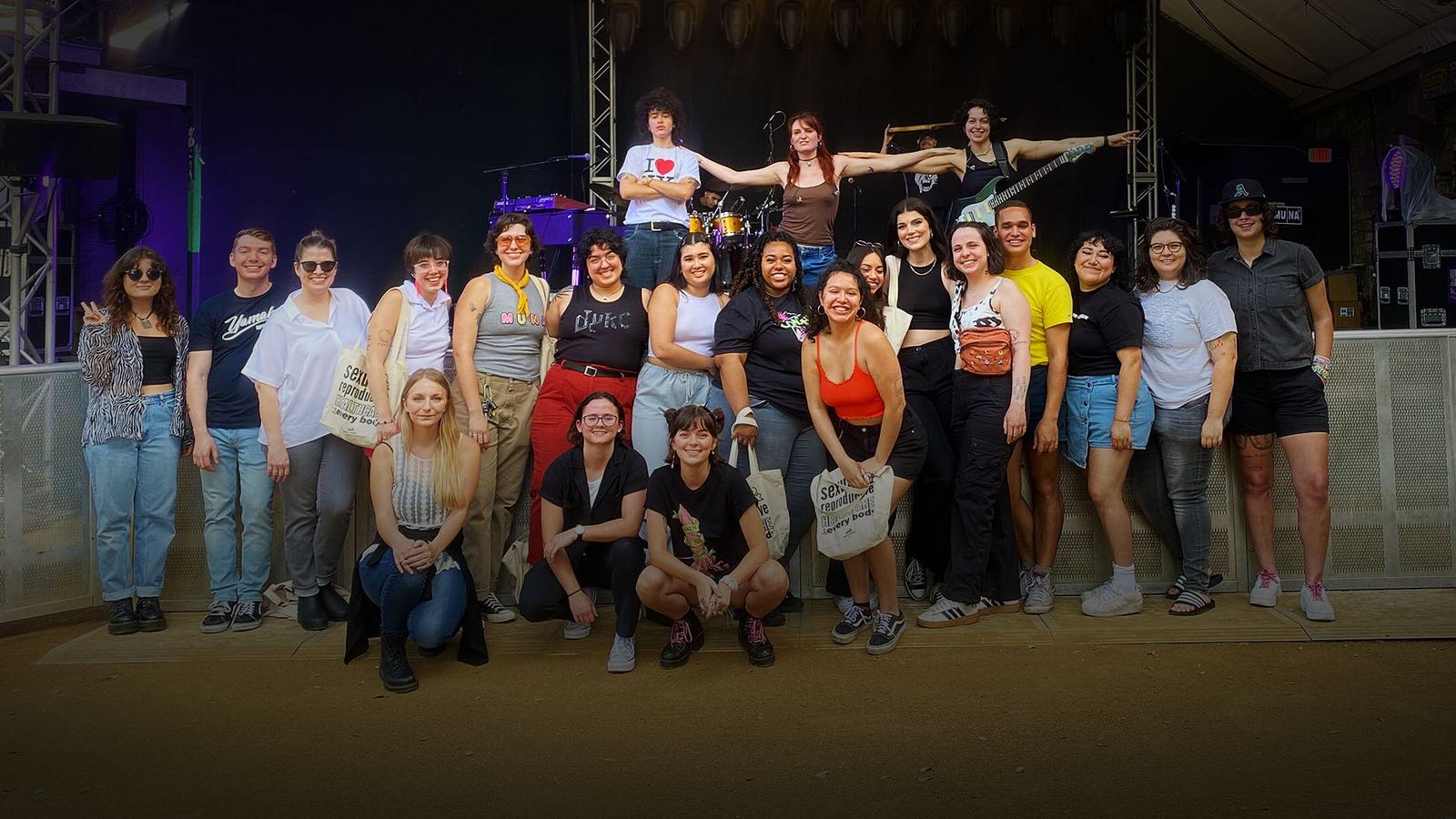 Fans and organizers gathered on stage at a show